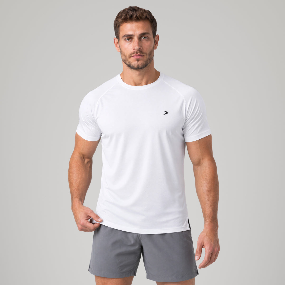Performance Tee blanca de Dropset, de frente con la mano en el ruedo
